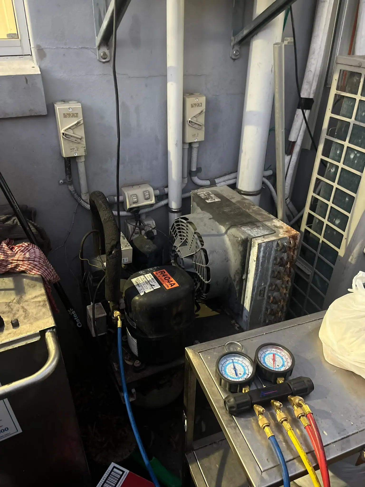 Technician working on the refrigeration system for an under-bench fridge unit
